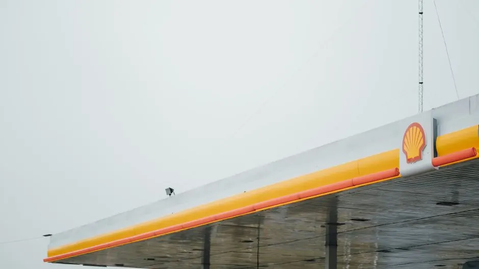 Minimalist view of a Shell gas station canopy against a cloudy sky, emphasizing simplicity and branding.